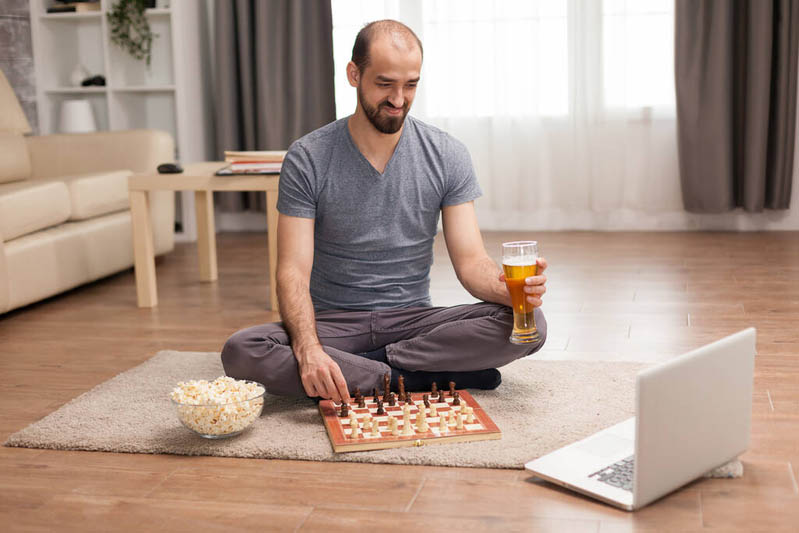 مرد نشسته بر زمین و مشغول شطرنج