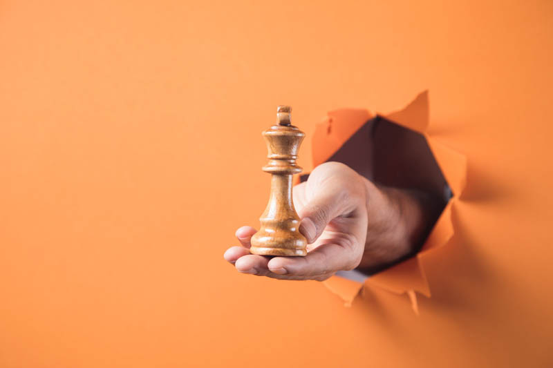 دستی که در امده و مهره شطرنج در دست دارد